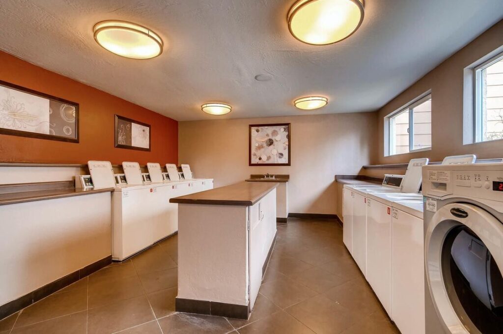 group laundry facility with lots of washers and dryers and a folding station