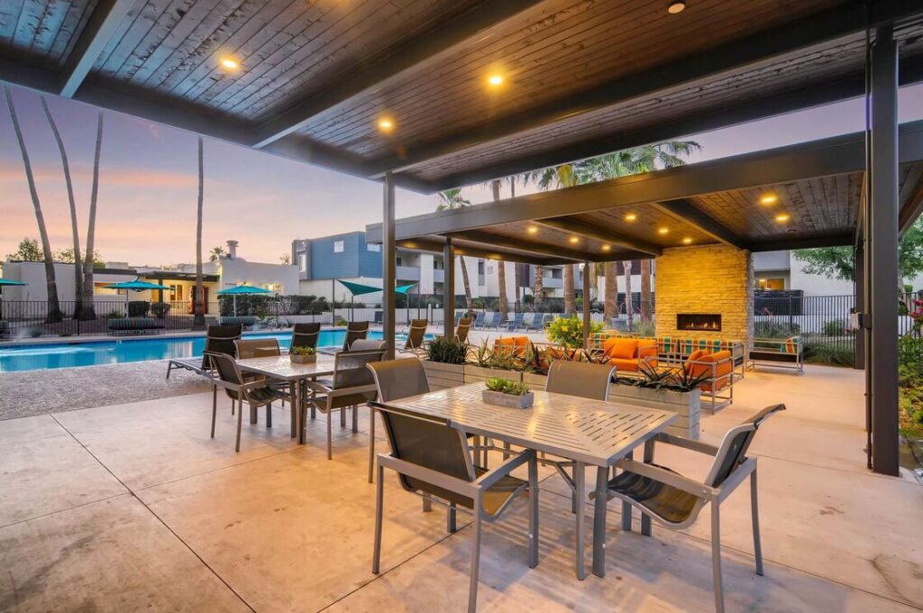 covered pavilion by the pool with tables and fire place
