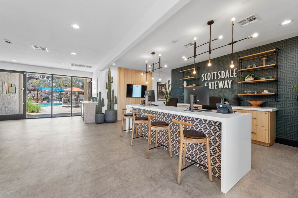 Leasing office lobby with a bar height desk and decorative tiles. Large window view to pool and patio.